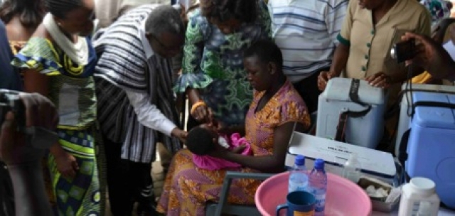 Baby Ernestina receiving Oral Polio Vaccine from the Minister of health
