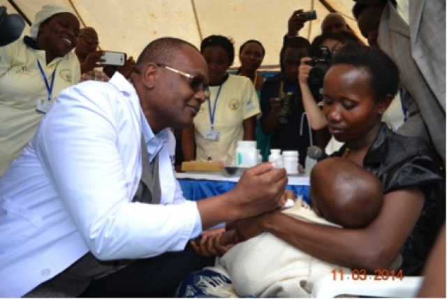 WHO Representative Dr. Delanyo Dovlo delivers immunization to child under 2 Sheila Mburu/WHO/2014