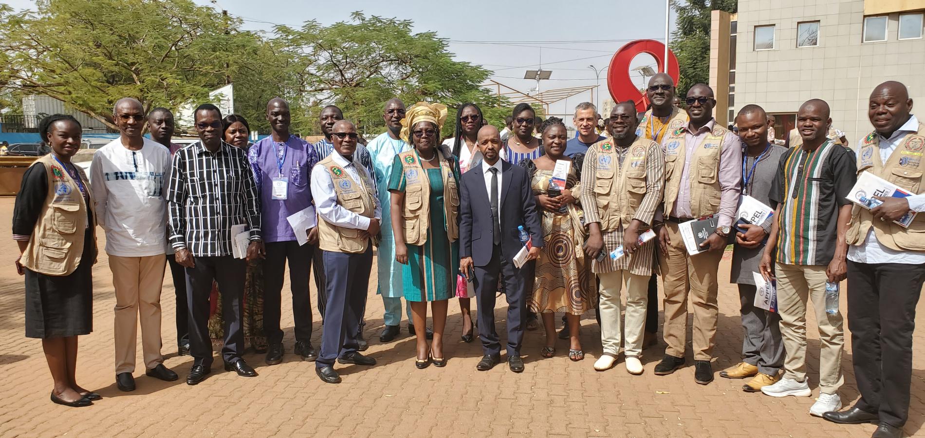 Une photo de famille de lauréats avec le Représentant de l’OMS au Burkina Faso, Dr Seydou Coulibaly, en chemise bleue à manche longueue