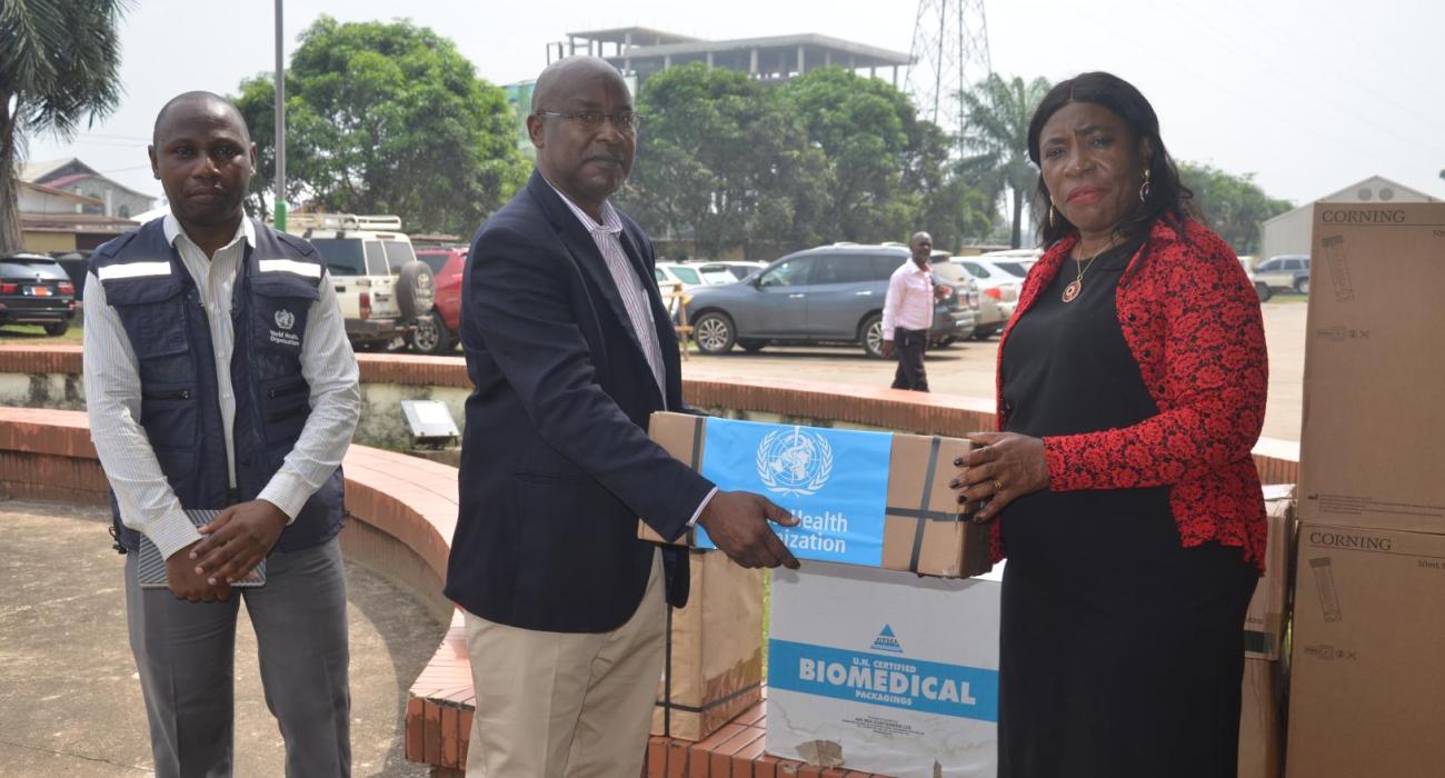  Dr. Cuallau Jabbeh Howe, the Assistant Minister of Health, receiving the donation from WHO OIC, Dr Abdullahi Sule