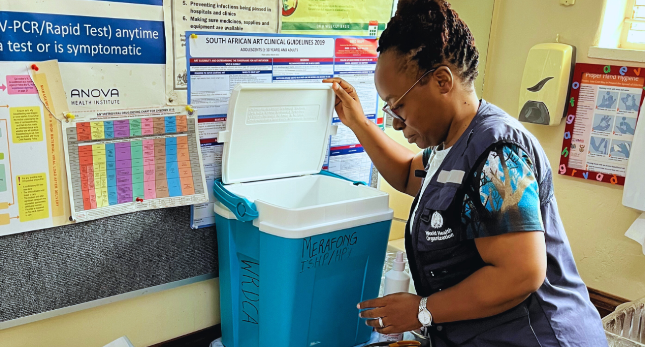 Dr. Simangele Mthethwa, Vaccine-Preventable Disease Surveillance Officer at WHO South Africa,  inspecting or preparing a vaccine cold box—a vital part of maintaining the cold chain required for storing and transporting vaccines at the correct temperature.