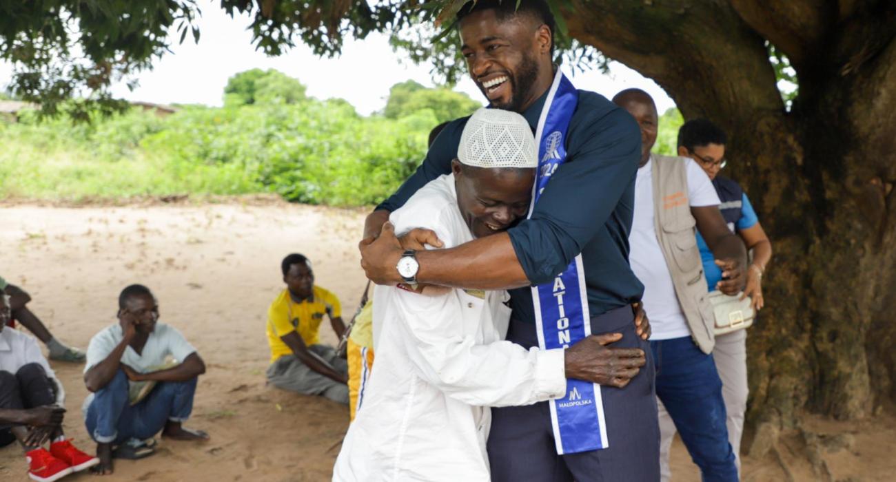 Mr. Supranational 2024, Dr. Fezile Mkhize, greets Pedro Mutaseque Paphelo, president of a leprosy selfcare group in Murrupula, Nampula, northern Mozambique, during a leprosy awareness campaign. Tiago Zenero/WHO Mozambique.